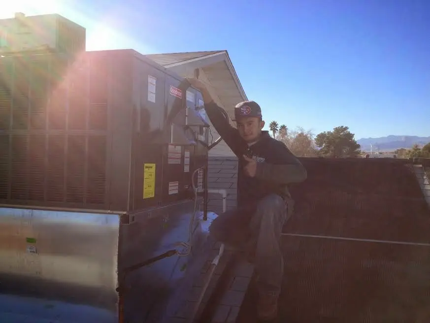 HVAC technician performing Air Duct Cleaning on a rooftop unit in Scottsburg